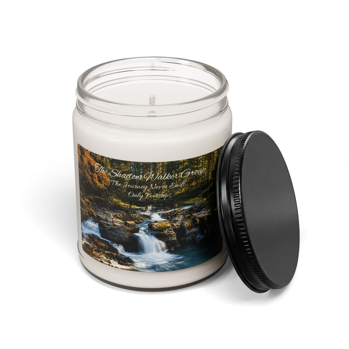 Open Be Still candle jar with river scene label and black lid beside it