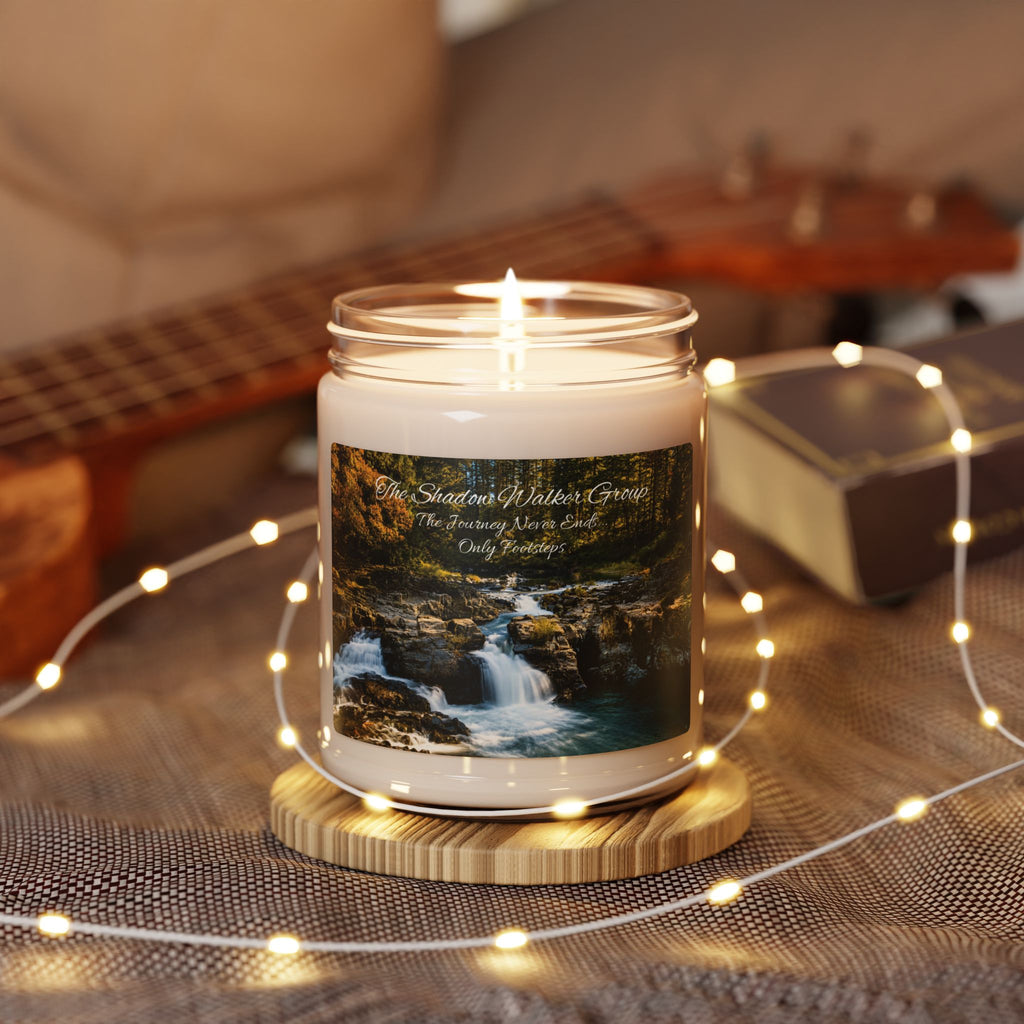 Lit Be Still river-scene candle on table with warm string lights