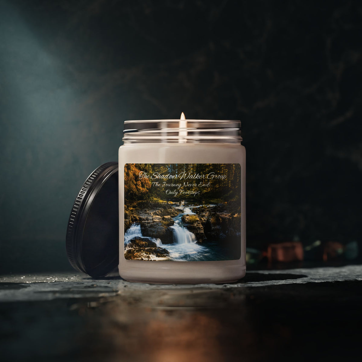 Lit Be Still soy candle with river scene label against a dark background