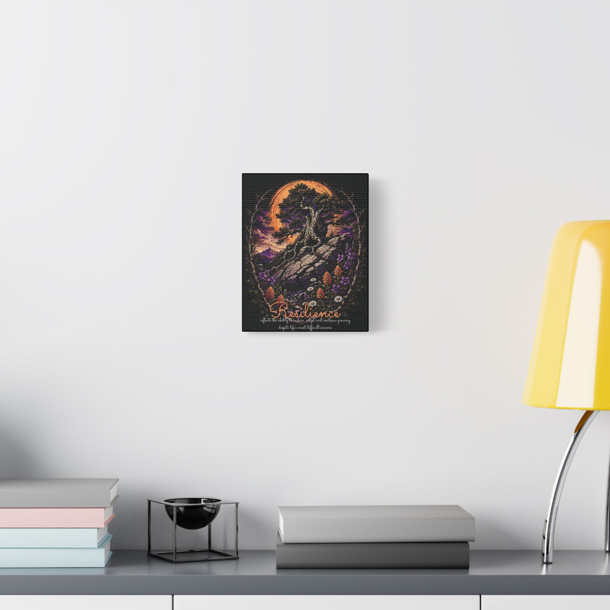 Resilience tree and wildflowers canvas displayed on a white wall above a console and lamp